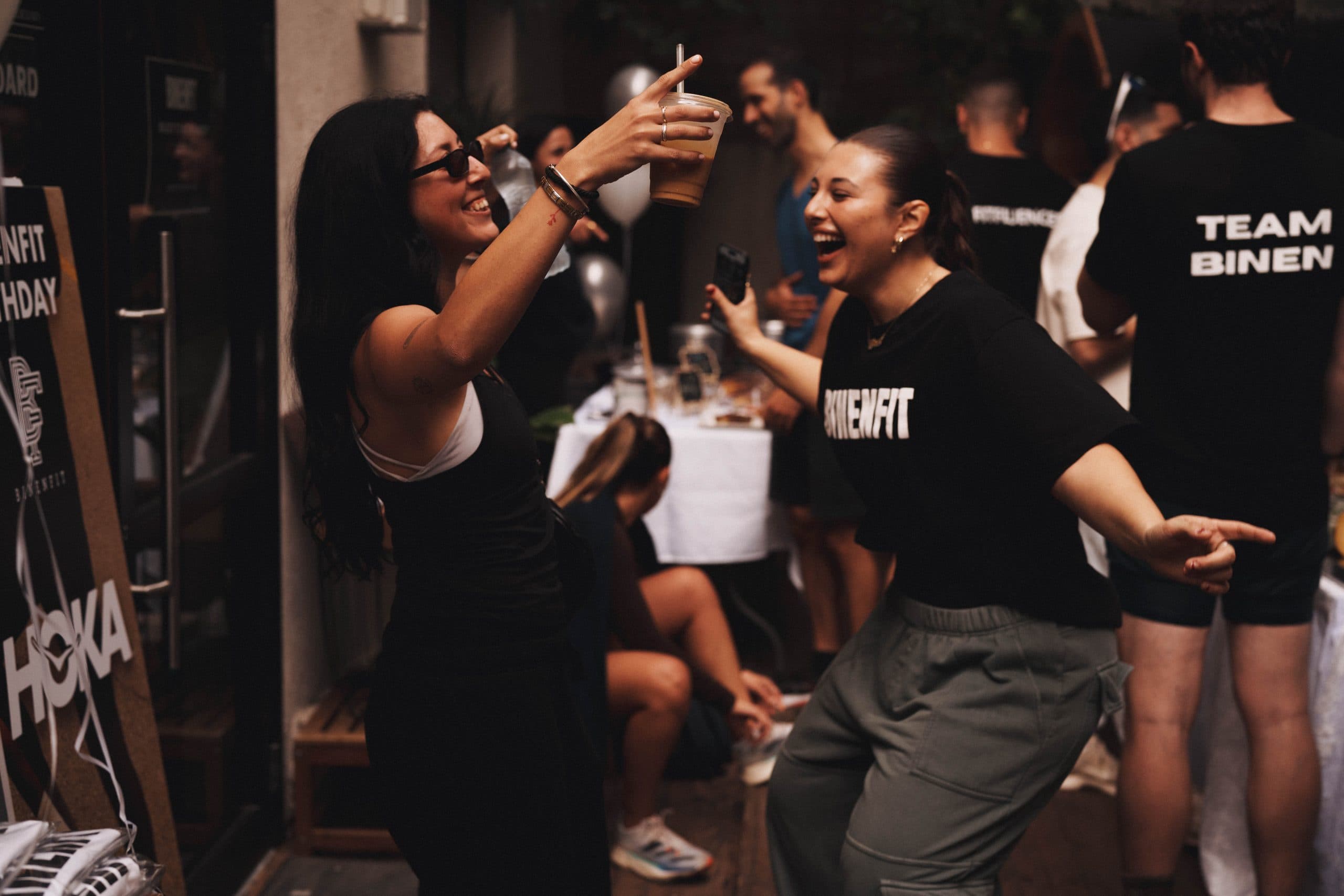 BINENFIT community members dancing and laughing at a community party